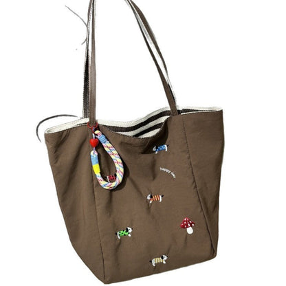 QIUDU embroidered canvas tote bag in red colorway lifestyle shot